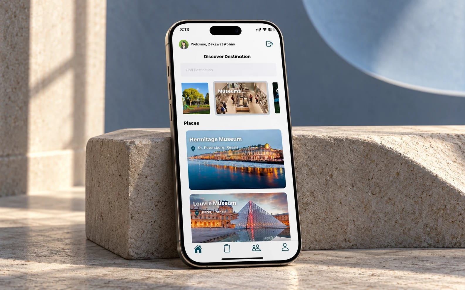 Dream Destination’s existing travel app displayed on a phone against limestone and a sculpted slate-blue backdrop.