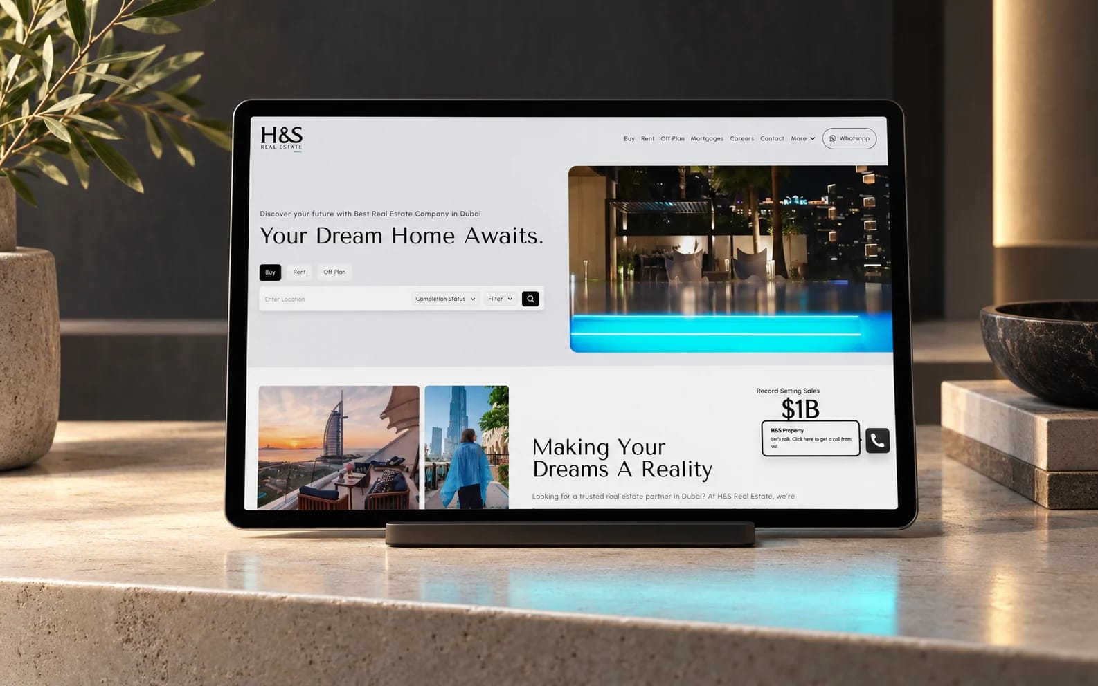 H&S Real Estate’s existing property website displayed on a tablet in a limestone and charcoal architectural setting.
