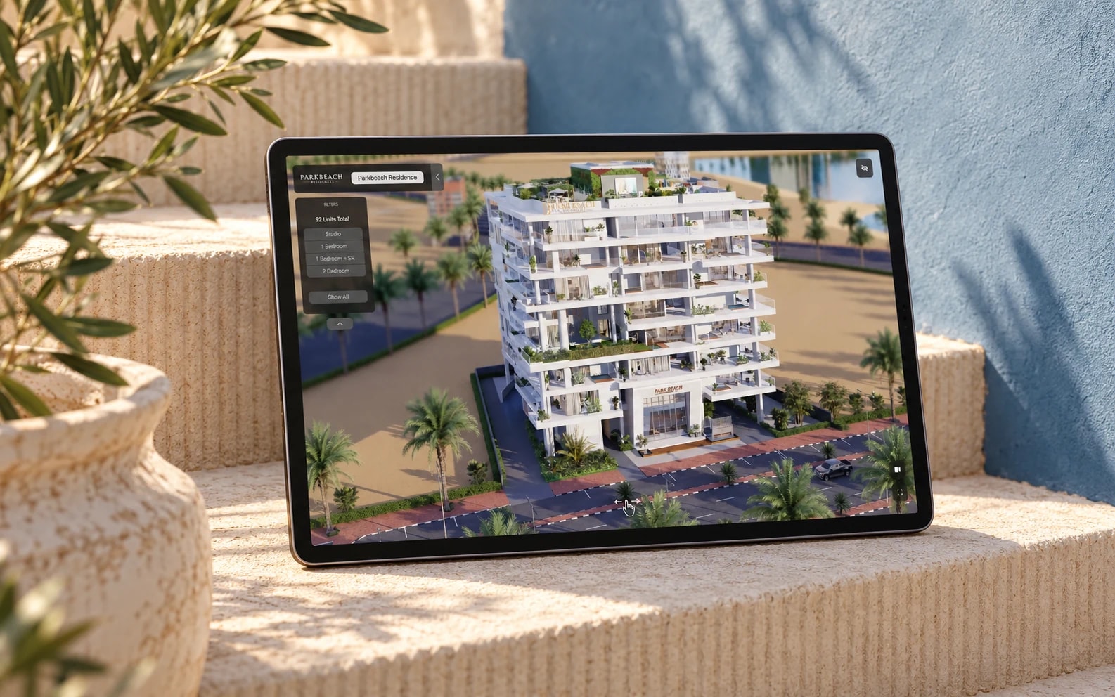 Park Beach Residences’ existing interactive property presentation on a tablet among sunlit ribbed stone steps.
